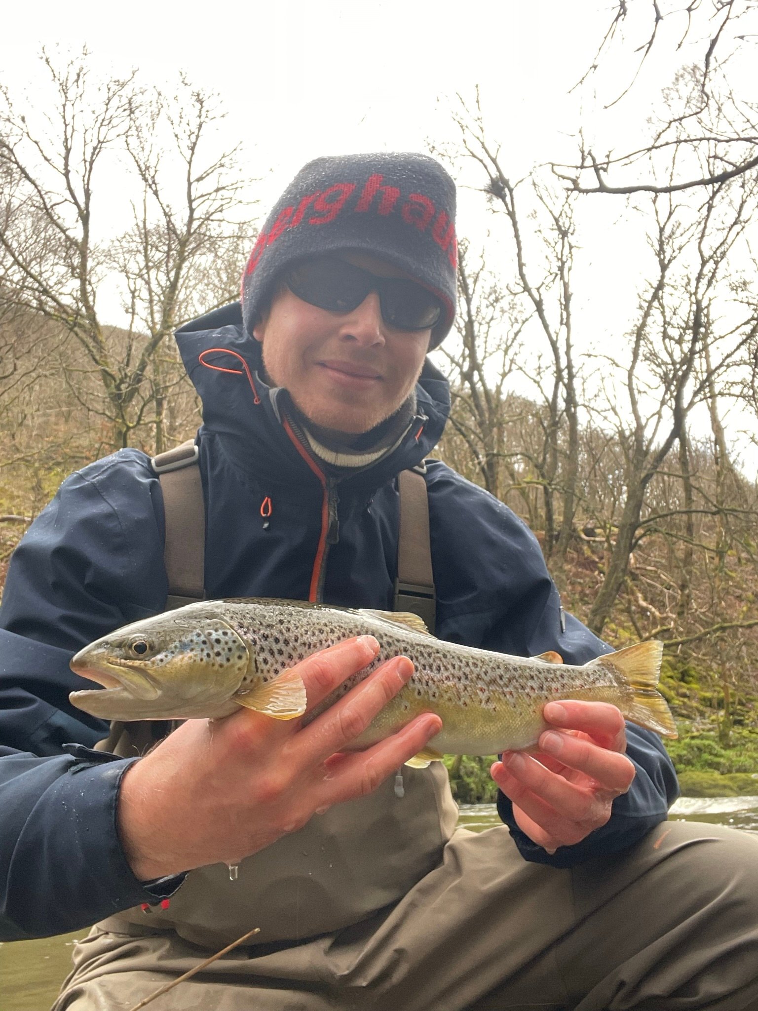 James holding a large brown trout caught from the upper river wye